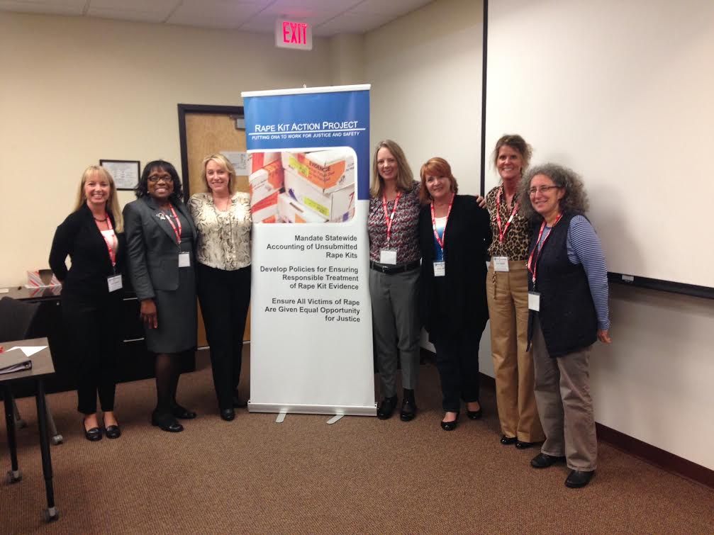 Survivors pose with a poster about the rape kit backlog